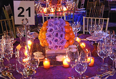 The spherical visuals, representing the event’s tagline (“If you can’t stand up … stand out”), appeared in the tabletop decor, where short centerpieces of blue curiosa roses and clementines sat atop pools filled with floating candles.