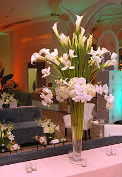 Arrangements of white flowers such as calla lilies, hydrangeas, and roses populated the party.