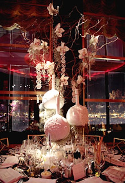 Strands of Lladró porcelain disks hung from white branches laced with orchids at the elegant setting created by Ernest de la Torre. (Flower-shaped porcelain votives nested around the base of the centerpiece.)