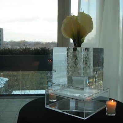 Calla lilies adorned an ice sculpture from Iceculture, situated on a cocktail table in front of a floor-to-ceiling window.