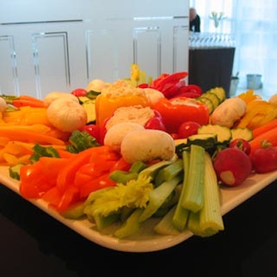 A tray of crudit?s featured celery sticks, mushrooms, slices of red and yellow peppers, and other fresh vegetables.