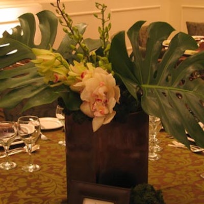 Green fronds filled brown leather containers to create another centerpiece design.