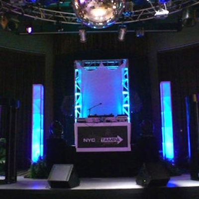 The four-foot-tall stage's background was draped in black, ten feet of trussing were added and uplit with color-changing LEDs, and risers elevated the DJ.