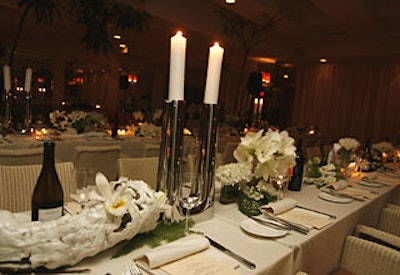 The centerpieces at the dinner consisted of white freesia, calla lilies, and peonies, accented with moss, mushrooms, and succulents, draped around Georg Jensen's silver pillar candlesticks and geometric plates.