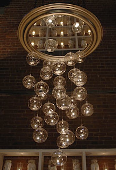 Among the numerous chandeliers on display was the Academy of Art's simple yet striking piece, which consisted of dangling, candle-filled globes strung through a framed mirror. The globes acted as 'bubbles of hope floating up,' according to Monty Parsons, a design student involved in the project. Designers placed a round mirror on the center of the table below the chandelier so that the mirrors bounced off each other, reflecting glimpses of the dining space.