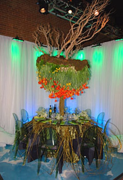 At Continental Airlines' table, David Beahm's gravity-defying tree drew eyes upward. Pieces of wood arranged at the top of the floral sculpture formed the tree's roots, while stems of weeping willow cascading down to the floor created its leaves. In between, Beahm anchored blooming bulbs in place with a metal frame so that they hung suspended above diners' heads.