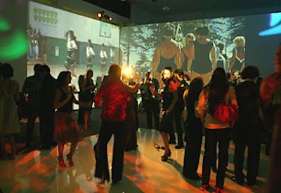 Muslin screens showing scenes of tennis and iconic movie clips superimposed with the crocodile logo surrounded the dance floor.