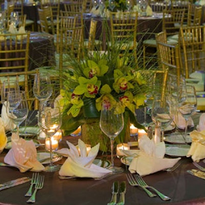 At the center of each of the 53 tables, sat centerpieces mixing green cymbidium orchids with bare grass.