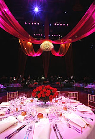 Guests supped at tables topped with pink cloths and huge bouquets of red roses.