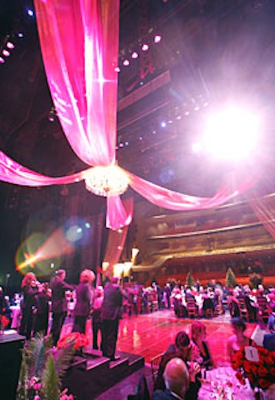 Lisa Stone draped 100 yards of pink glass-sheen chiffon above and behind the stage, crossing two strands overhead and dangling a giant chandelier where they overlapped.