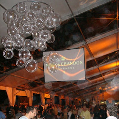 The tent's roof consisted of nine clear and nine white alternating panels. Bubble chandeliers added to the decor, while hanging screens were used to display the Moet & Chandon logo.