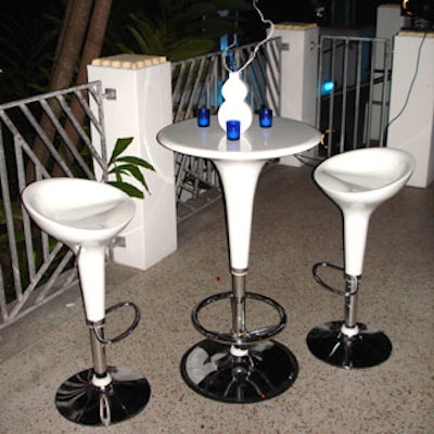 The rear terrace was furnished with sleek, white, modern furniture and blue votive candles, in keeping with the color theme.