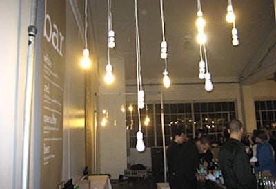 Compact fluorescent lightbulbs, strung together in clusters on repurposed white wiring, lit the space, and a long sheet of recycled paper above the bar listed the night’s refreshments, which included an organic signature cocktail, a local microbrew, and organic red and white wines.