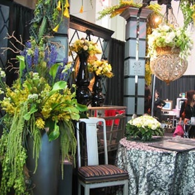 D?cor & More designed a booth that was heavy with lush florals, custom made furnishing and seat covers, and a mirrored backdrop.