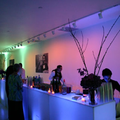 Bartenders served cocktails from behind glowing plexiglass bars decorated with flowers from Parrish Designs.