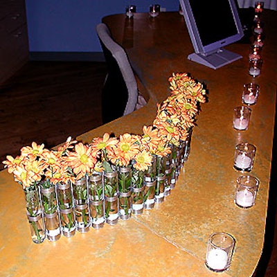 Ariston Florists placed orange daisies in stainless steel and glass vases that matched KPE's office furniture.