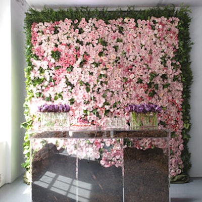 At the end of the entrance hall, a Lucite tasting bar filled with wood chips and balsa wood stood in front of a wall of pink damask roses that gave off a slight aroma.