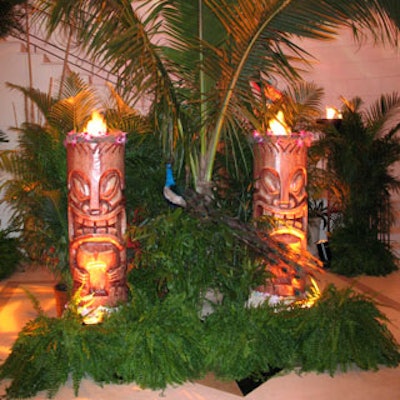 In the 'Festivale de Fuego' lobby, tiki god flame pots were accented with orchids, lush foliage, and a beautiful peacock.