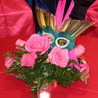 This pink rose and mask centerpiece gave an added shot of festival appeal to the rest of the similar decor.