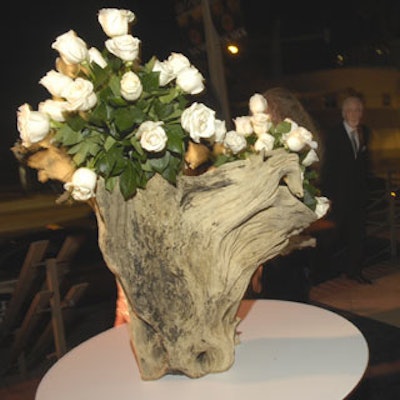A variety of floral displays were used, including white roses arranged in driftwood vases.