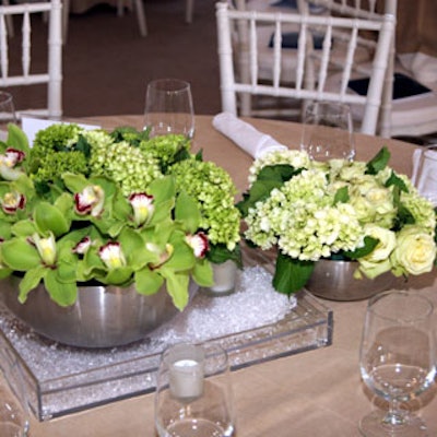 Alternate centerpieces consisted of green cymbidium orchids, white roses, and green mums displayed in silver bowls with Lucite trays and white votive candles.