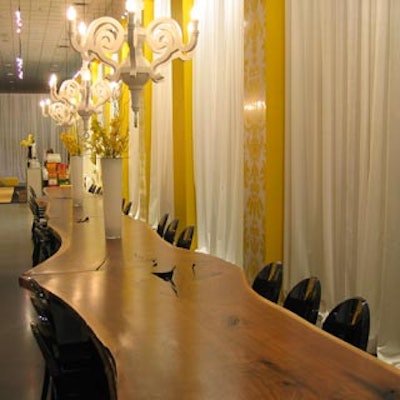 Designer Armin Martiros of Ma Zone created a dining room vignette with a 33-foot Canadian black walnut slab table from Broadbent Furniture, Paper chandeliers from Moooi, and chairs from Contemporary Furniture Rentals.