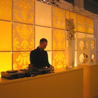 DJ Geoff Kelleway performed in front of a yellow-lit acrylic-tile wall.