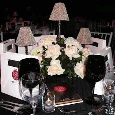 Some tables featured low table centerpieces with elegant white blooms and green foliage accompanied by trios of silver beaded mini tea-light lamps.