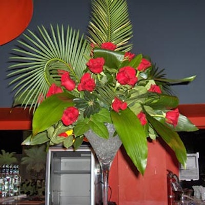 Large martini glasses filled with clear gel and topped with lush tropical foliage and bright red roses decorated the bars.