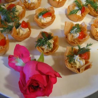 Amazing Food Services passed herb chevre mousse and cherry tomato in phyllo cups on white platters with fresh roses for decoration.