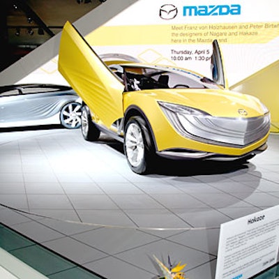 Mazda played up its concept car, the Hakaze, and the bird of paradise flower that inspired its design with a bright yellow-and-white booth and a giant polygon-shaped wall of flat-screen video monitors.