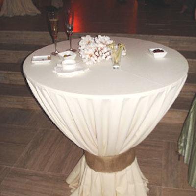 High-top tables were covered in an off-white fabric, bunched, and tied with burlap. Simple coral displays added to the seaside ambience.