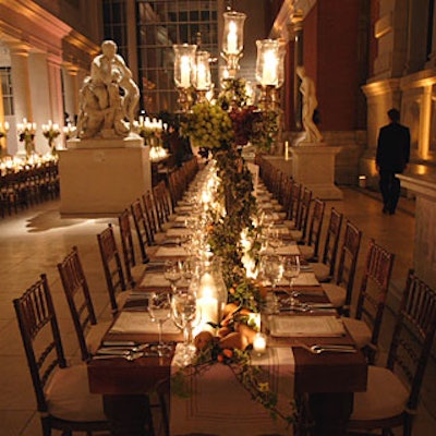 Custom wood tables, candelabras covered with grapes and ivy imported from San Remo, and touches of greenery set the scene for gardenlike dinner in the Carroll and Milton Petrie European Sculpture Court.