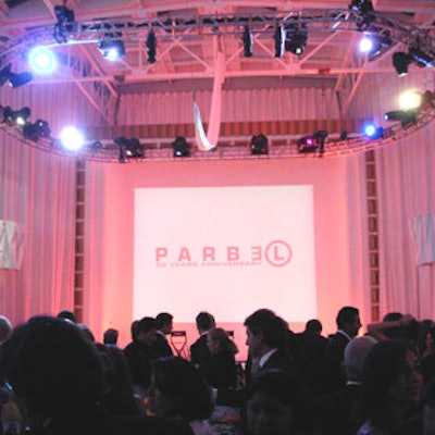 The main room featured a large screen set behind the stage. Dramatic floor-to-ceiling white vinyl curtains enveloped the space.