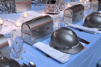 Tabletops adorned with silver hats, trucks, and lunch boxes set the scene inside the dinner tent.