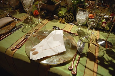 The three different table designs’ commondenominator was the curlicued copper flatware.