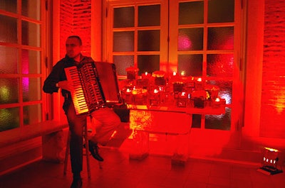 Guests entered the embassy's foyer to find an accordion player and vibrant red lighting. Also present was an altarlike display of roses and candles floating in red glass containers.