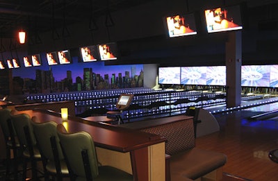 Panels over the pins can display music videos, corporate logos, or moving graphics. Cozy banquettes and a bench with bar stools sit at each lane.