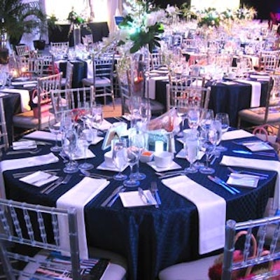 Chair-man Mills provided navy blue table linens and clear chiavari chairs, while Blossoms & Brant Florists supplied white floral centerpieces with blue LED lights.
