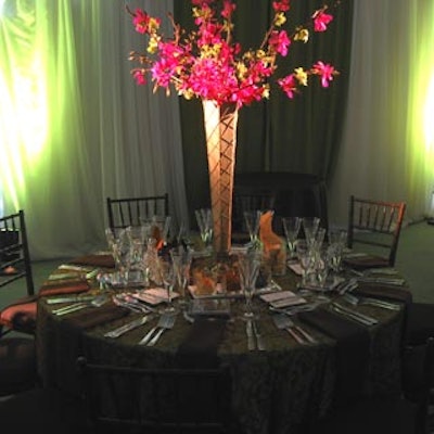 Chair-man Mills supplied alternating kiwi and damask patterned brown and gold coloured dining table linens, while Forget Me Not Flowers chipped in tall vase centrepieces covered in fabric matching the linens.
