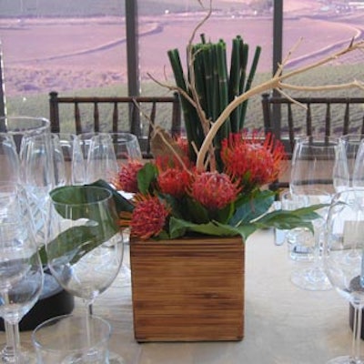 Centrepieces included wildflowers with tropical foliage and rustic twigs in wooden containers.