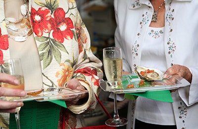 As guests entered the event, staffers handed them small plastic trays that made juggling food and drinks easier.