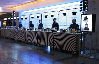 Light fixtures showing top hats, as seen on this indoor bar, were just one more way in which designer Susan Edgar played off the Tony awards logo.