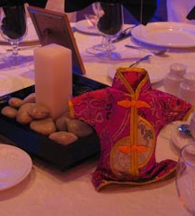 Table decor included small, black frame box centerpieces, each with a pillar candle and an assortment of river rocks inside, and a sand-filled mini kimono that served as a weight for the balloon treatment floating overhead.