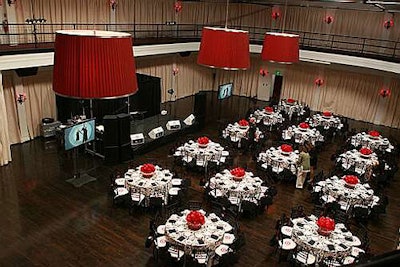Black and white cloths topped tables, alongside bright-red flower arrangements.