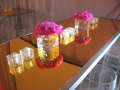 Church Street Flowers adorned gold-coloured tables with clear glass votive holders and small square vases filled with hot-pink carnations.