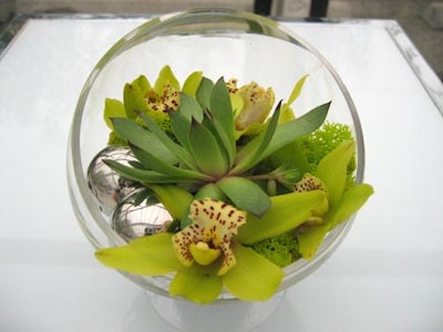 Brandy glasses filled with wild orchids, lime-coloured moss, and silver balls from San Remo Florists topped square white cocktail tables in the lounge.