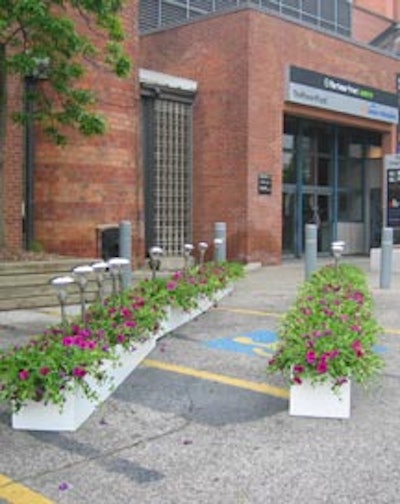 White planter boxes filled with purple and green potted plants and garden lights formed a pathway from the Power Plant doorway to the entrance to the tent in the parking lot.