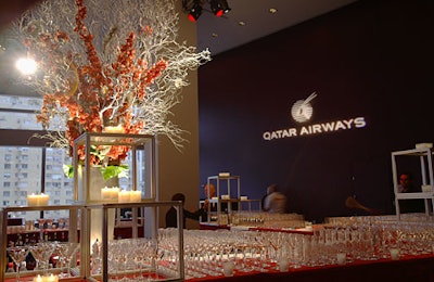 An arrangement of silver branches and orchids with accents of silver ornaments towered over attendees during the cocktail hour.