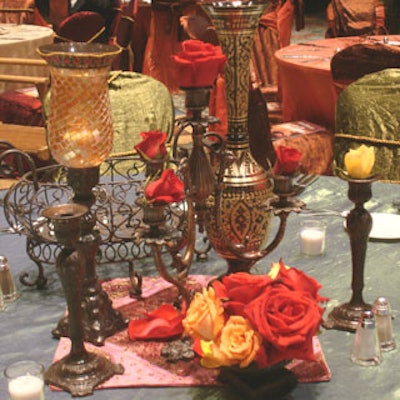 Candelabra, decanters, and other Indian-style planters with flowers in deep reds, golds, and oranges, served as centerpieces in the grand hall.